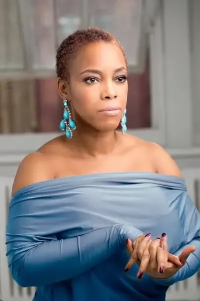 April in a blue off-the-shoulder wrap, smiling