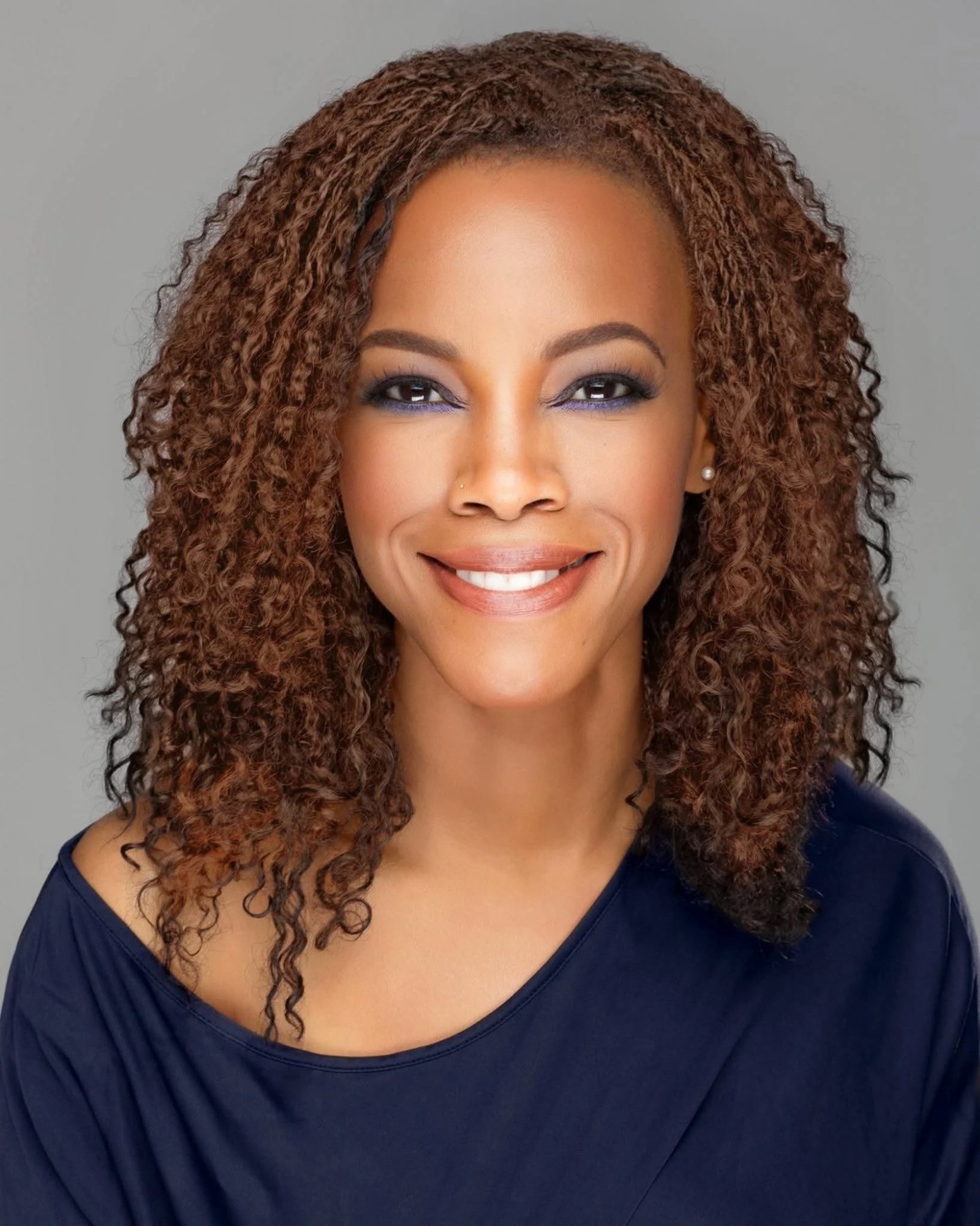 April Yvette Thompson, studio headshot in a navy top